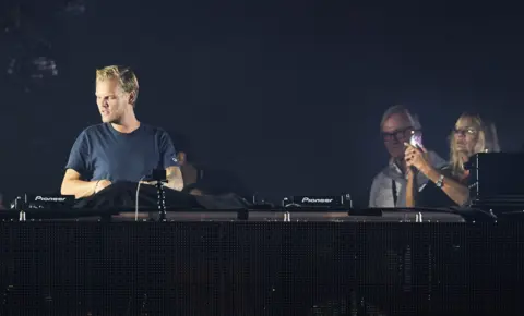 Hillergen Andreas/Aftonbladet/IBL Bildbyrå Avicii's parents Klas and actress Anki Liden stand behind him on stage in 2016