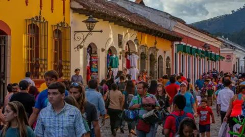 Getty Images Tourists crowd the streets of Antigua