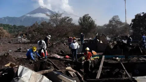 Getty Images Locals search through the remnants of San Miguel Los Lotes, which was buried under ash and rock