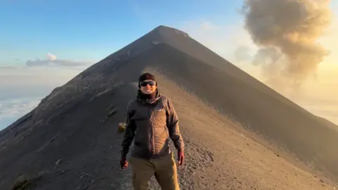 Getty Images Alex Gordon smiles for the camera on top of an ash-covered volcano.