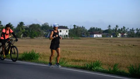 Project 1000 Natalie Dau and her fitness coach Arthur Tong on a bicycle