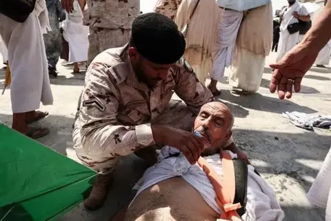 Getty Images An official gives a man lying on his back water