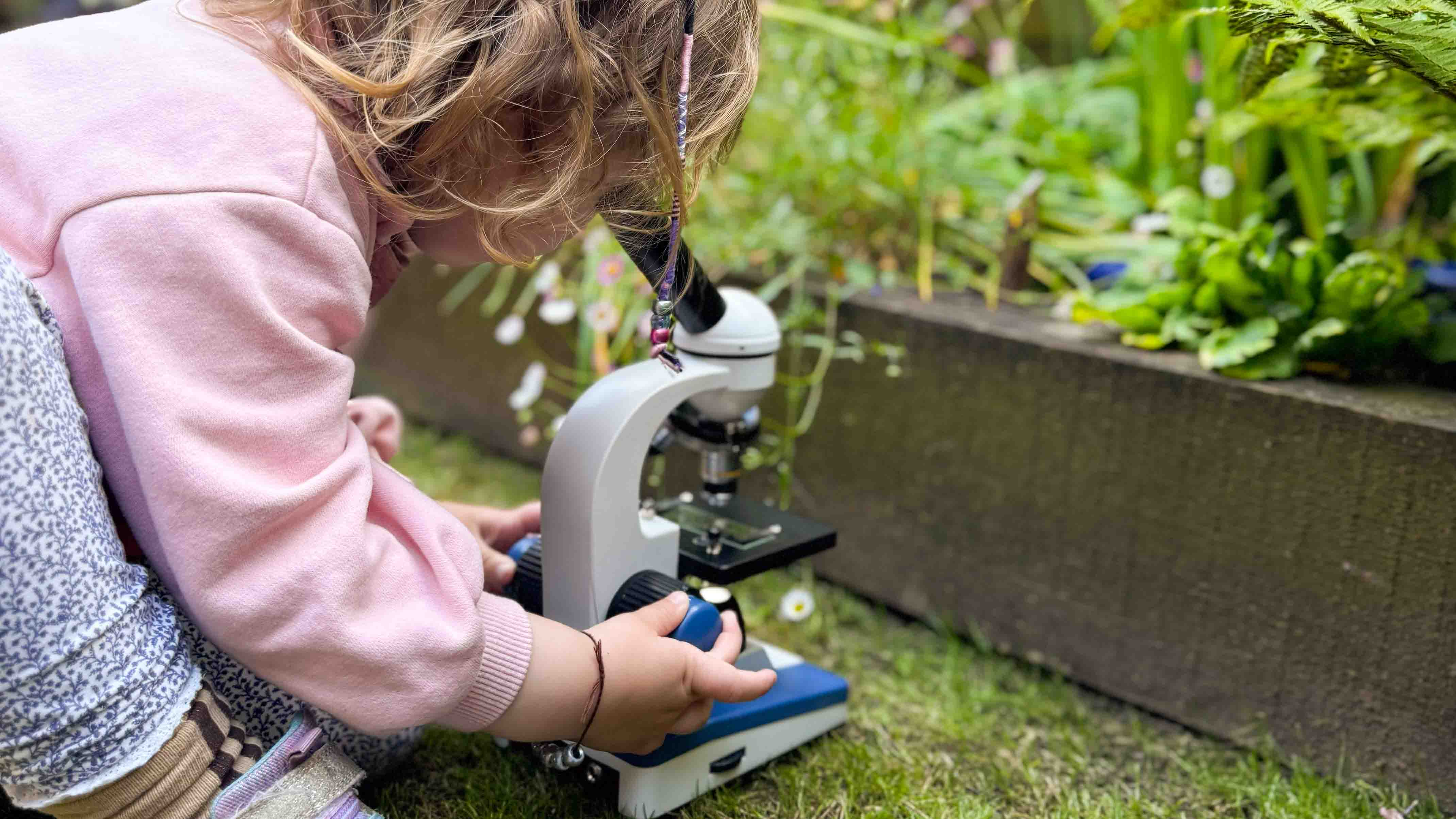 Microscope being used by a child next to a pond