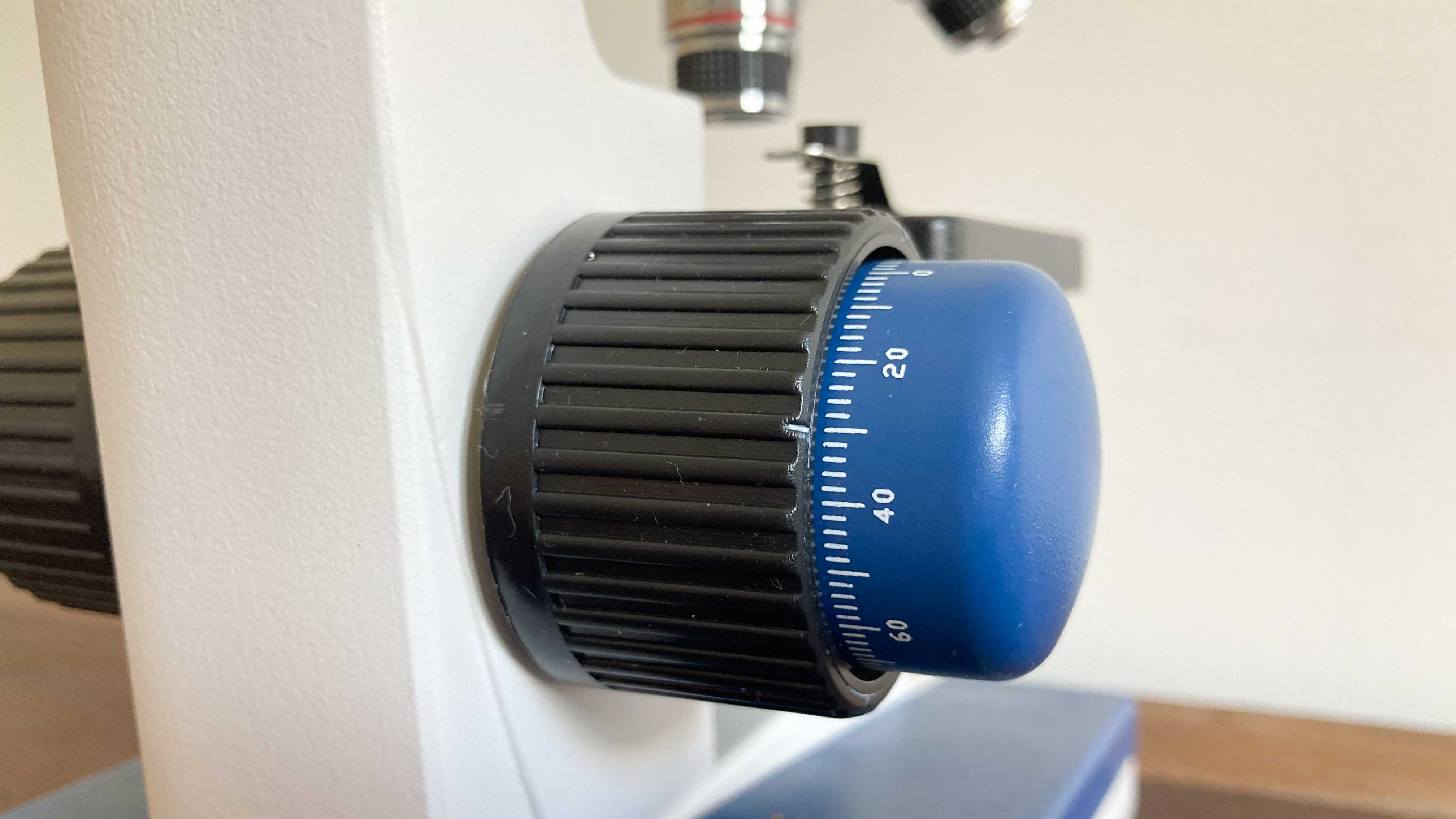 A close-up view of the focusing knob on the microscope