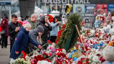 EPA Russians mourn and place flowers at the Crocus City Hall concert venue, six days after a terrorist attack in Krasnogorsk, outside Moscow, Russia, 28 March 2024