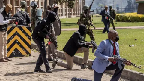 AFP Kenya Police officers and security personnel take position to protect the Kenyan Parliament as protesters try to storm the building during a nationwide strike to protest against tax hikes and the Finance Bill 2024 in downtown Nairobi, on June 25, 2024
