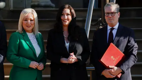 Reuters Michelle O'Neill, Emma Little-Pengelly and Sir Keir Starmer outside Stormont Castle