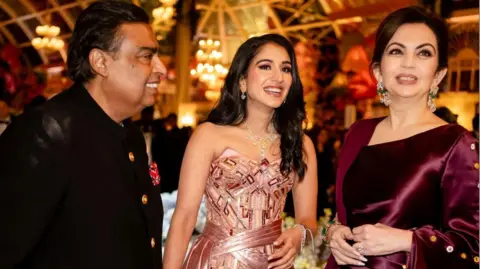 Reuters Mukesh Ambani, the chairman of Reliance Industries, Radhika Merchant and Nita Ambani, share a moment during the pre-wedding celebrations