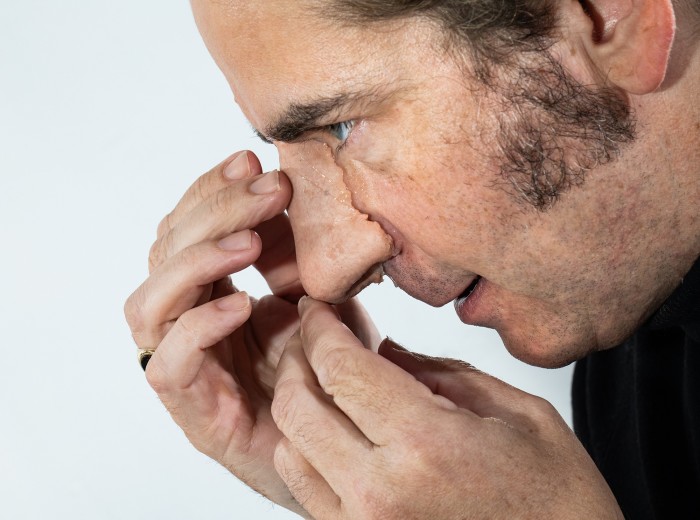 A man appears to be fitting a fake nose