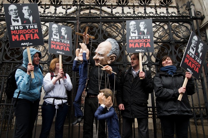 Protesters holds signs and puppets outside the High Court in central London in 2012 