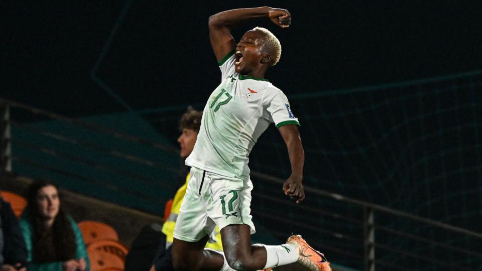 Zambian footballer Racheal Kundananji celebrates scoring a goal by jumping in the air with her right arm raised