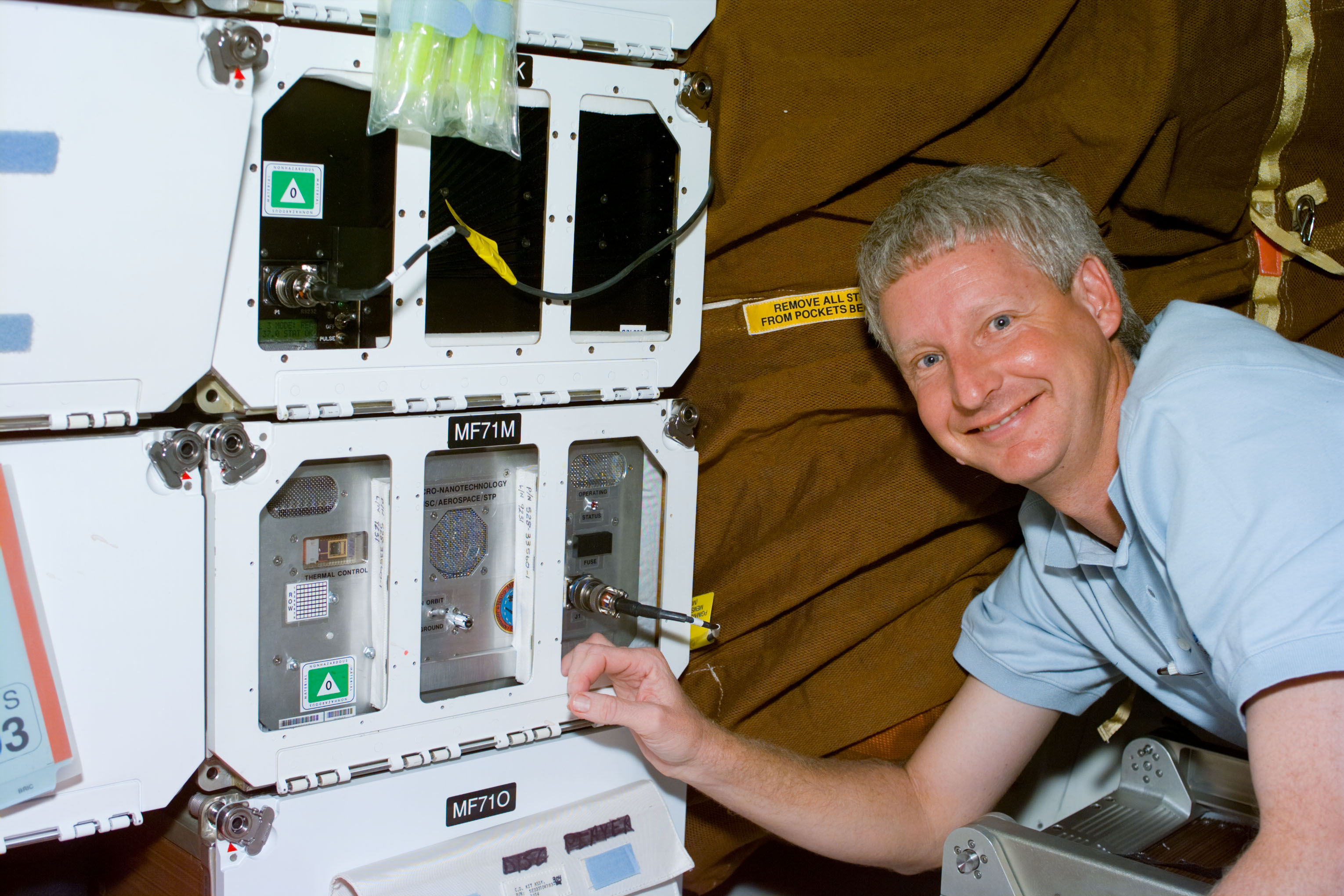 Stephen A. Hawley checks the status of the Micro Electromechanical Systems experiment