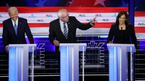 Getty Images Harris seen at a presidential primary debate in 2019, alongside Bernie Sanders and Joe Biden