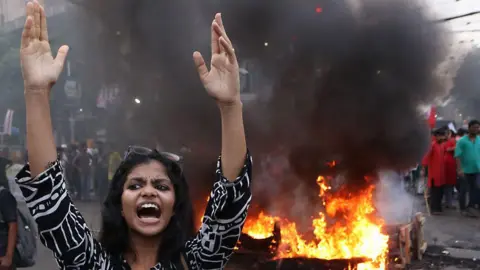 Getty Images An activist is protesting and burning an effigy and tires as they block a road during a protest against a recent scam in the NEET and UGC-NET exams in Kolkata, India, on June 25, 2024. 