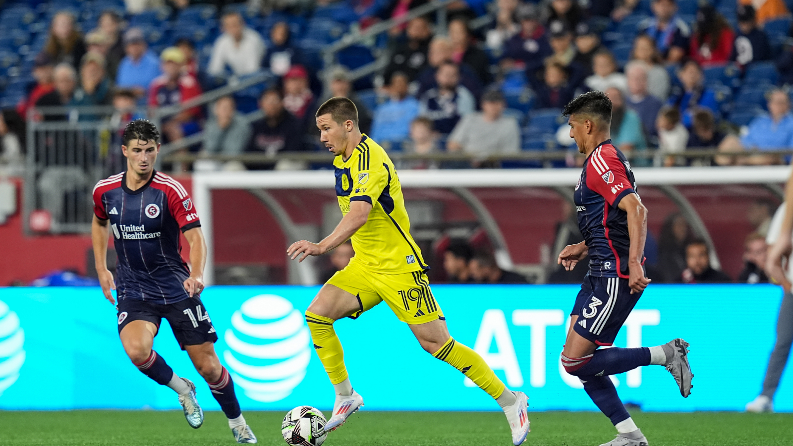 Alex Muyl #19 of Nashville SC dribbles as Ian Harkes #14 of New England Revolution and Xavier Arreaga #3 of New England Revolution defend during a Leagues Cup 2024 game between New England Revolution and Nashville SC at Gillette Stadium on August 6, 2024 in Foxborough, Massachusetts.