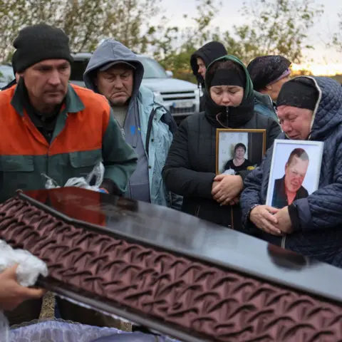 YAKIV LIASHENKO/EPA-EFE/REX People attend the funeral ceremony of fellow villagers killled in a Russian strike, at the cemetery of Hroza, Kupiansk district, Kharkiv region, Ukraine, 09 October 2023.