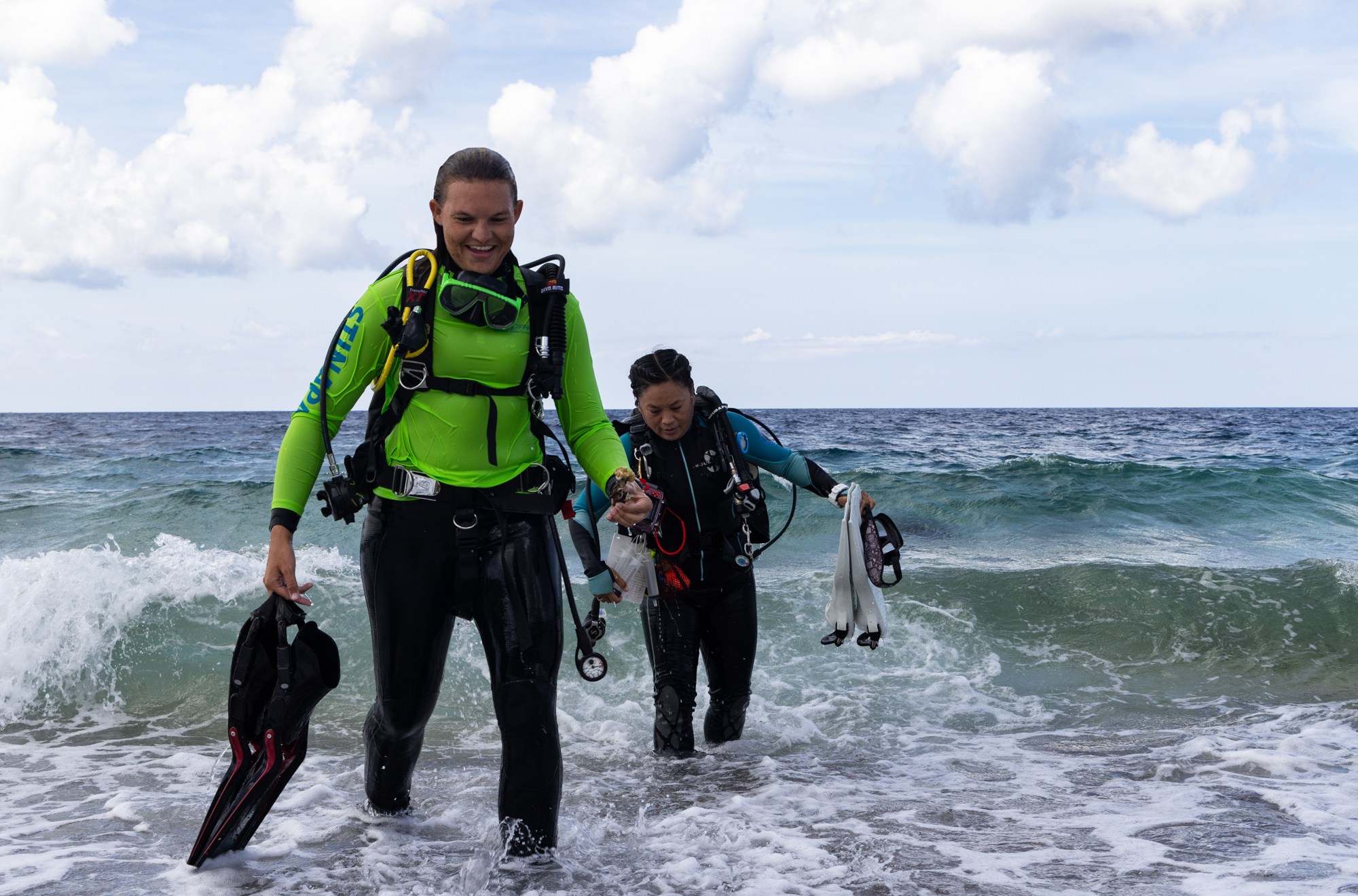 De Kool and Toy exit the water after a dive to treat coral.