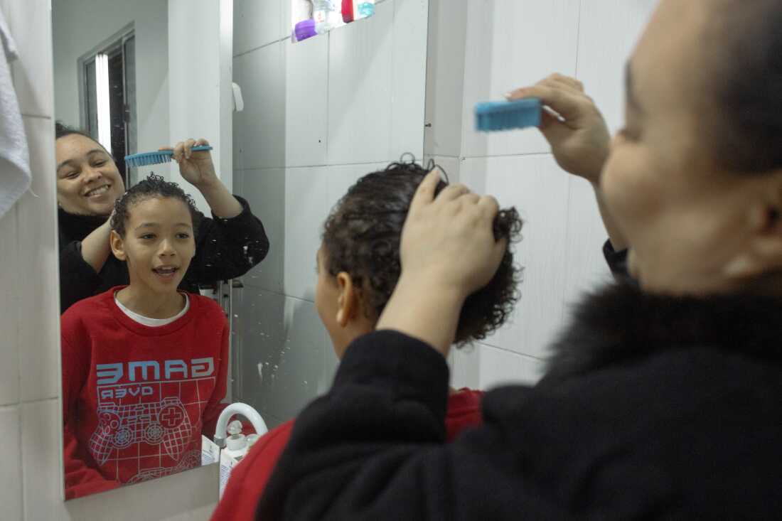 SÃO PAULO, SP, BRAZIL - AUG 13, 2024: Érica Lacerda de Souza helps her son Henrique fix his hair. She says that this is one of the boy's vanities and that he does it every day before going to school.