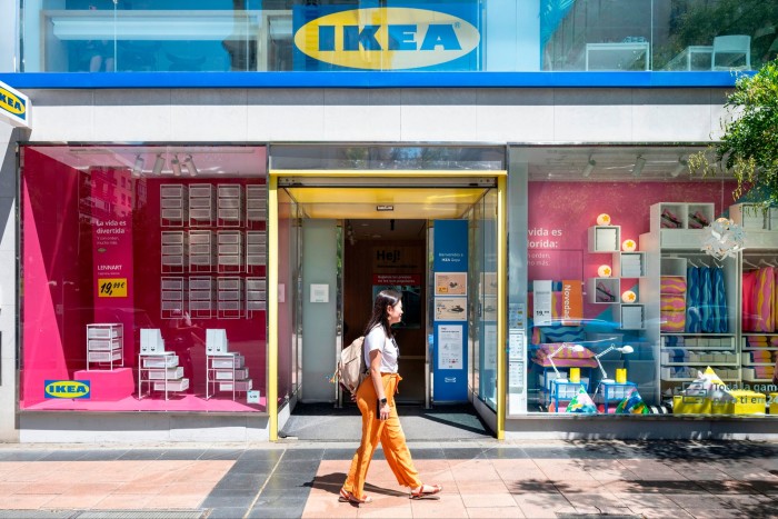 A woman walks past an Ikea store front 