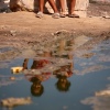 Palestinian children are sitting on a street flooded with sewage water in Deir el-Balah, in the central Gaza Strip, on July 23, 2024.  Polio was detected in multiple samples of Gaza's wastewater and now infectious disease experts suspect there are mild cases of the disease already in the population.  The World Health Organization says it is ''extremely worried'' that diseases, such as polio,  could cause more deaths than war injuries. 