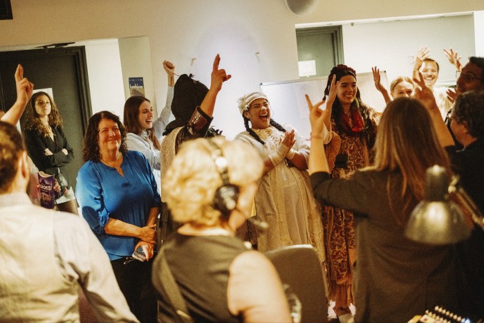 Group shot of cheerful looking actors backstage before performing