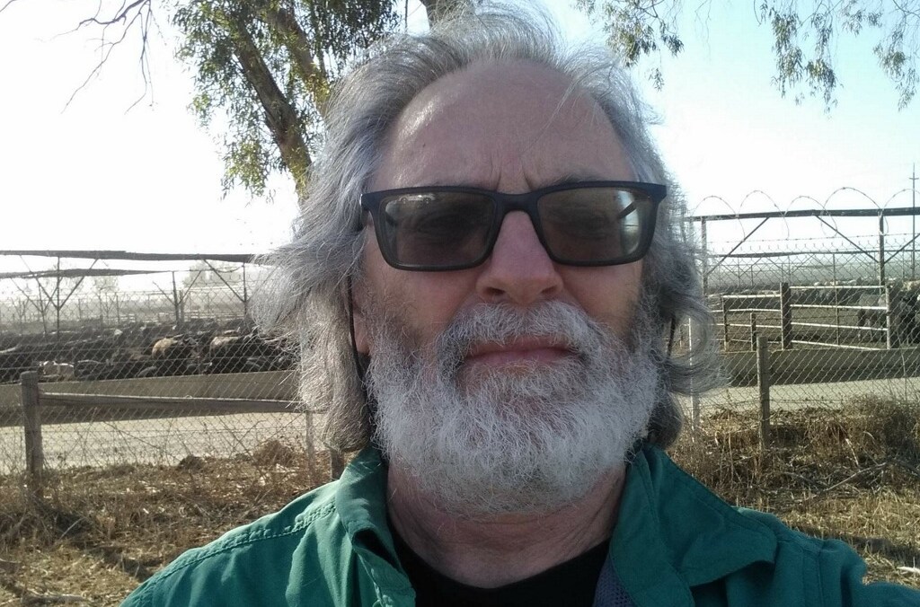 Todd Shuman, a longtime Sierra Club volunteer, has faced resistance against his efforts to get the organization to do more to take on the meat and dairy industries. Here he is standing outside a cattle feedlot in California.