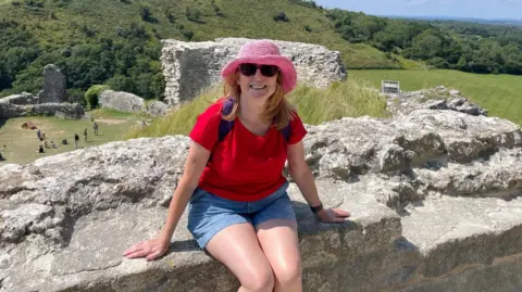 Kelly Burton Kelly Burton is seen sat on a wall in the sunshine