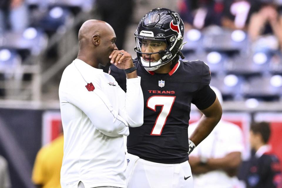 Houston Texans head coach DeMeco Ryans speaks with quarterback C.J. Stroud on the sideline during a game.