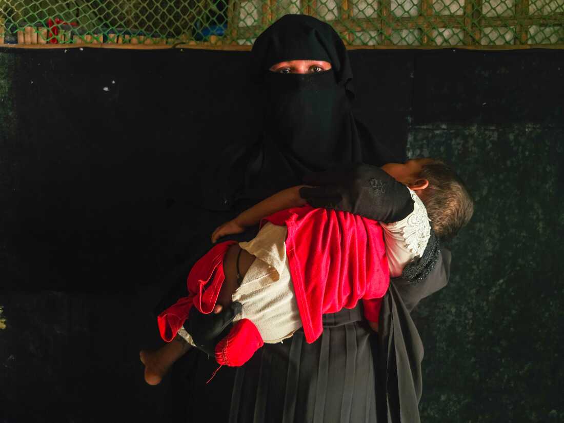 A Rohingya woman who fled with her child to Bangladesh after her husband was killed in a drone attack by the Arakan Army.