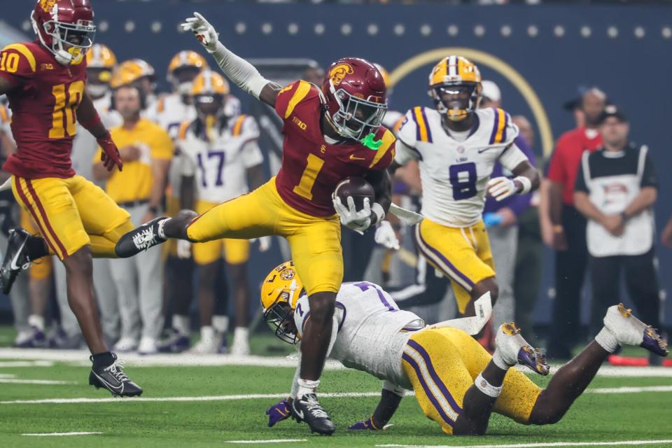 USC wide receiver Zachariah Branch avoids a tackle attempt by LSU linebacker Harold Perkins Jr.