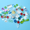 Various pieces of colorful trash, such as plastic bottle caps and plastics forks, are arranged in the shape of a human brain, on a light blue background.