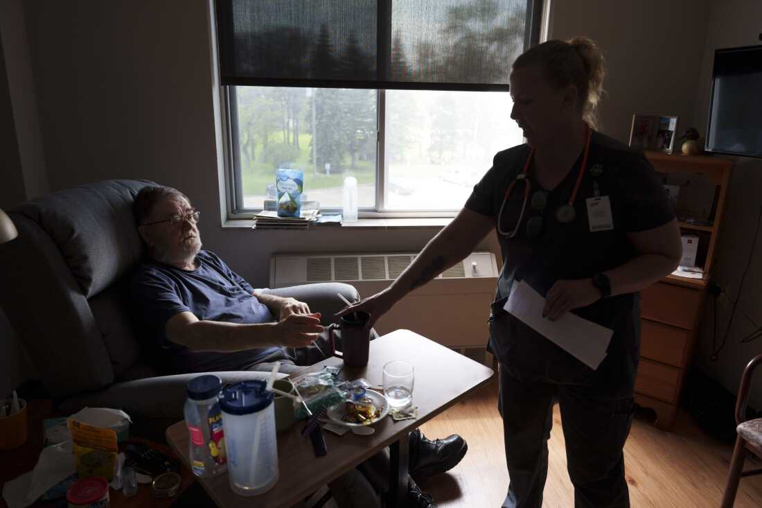 Registered nurse Susan Eback checks in on Sherwood Haakenson in his room at the Heart of America Medical Center in Rugby, N.D., on May 14. Haakenson had been suffering from multiple fainting episodes in recent months.