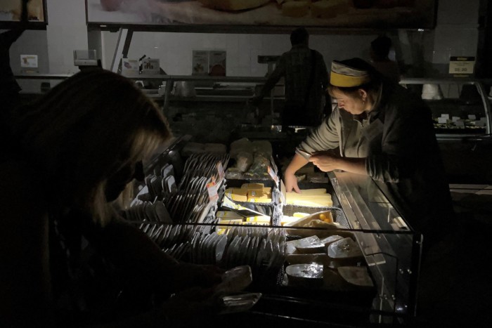 A seller serves a customer at a supermarket during a blackout in Kyiv, Ukraine on August 20 2024