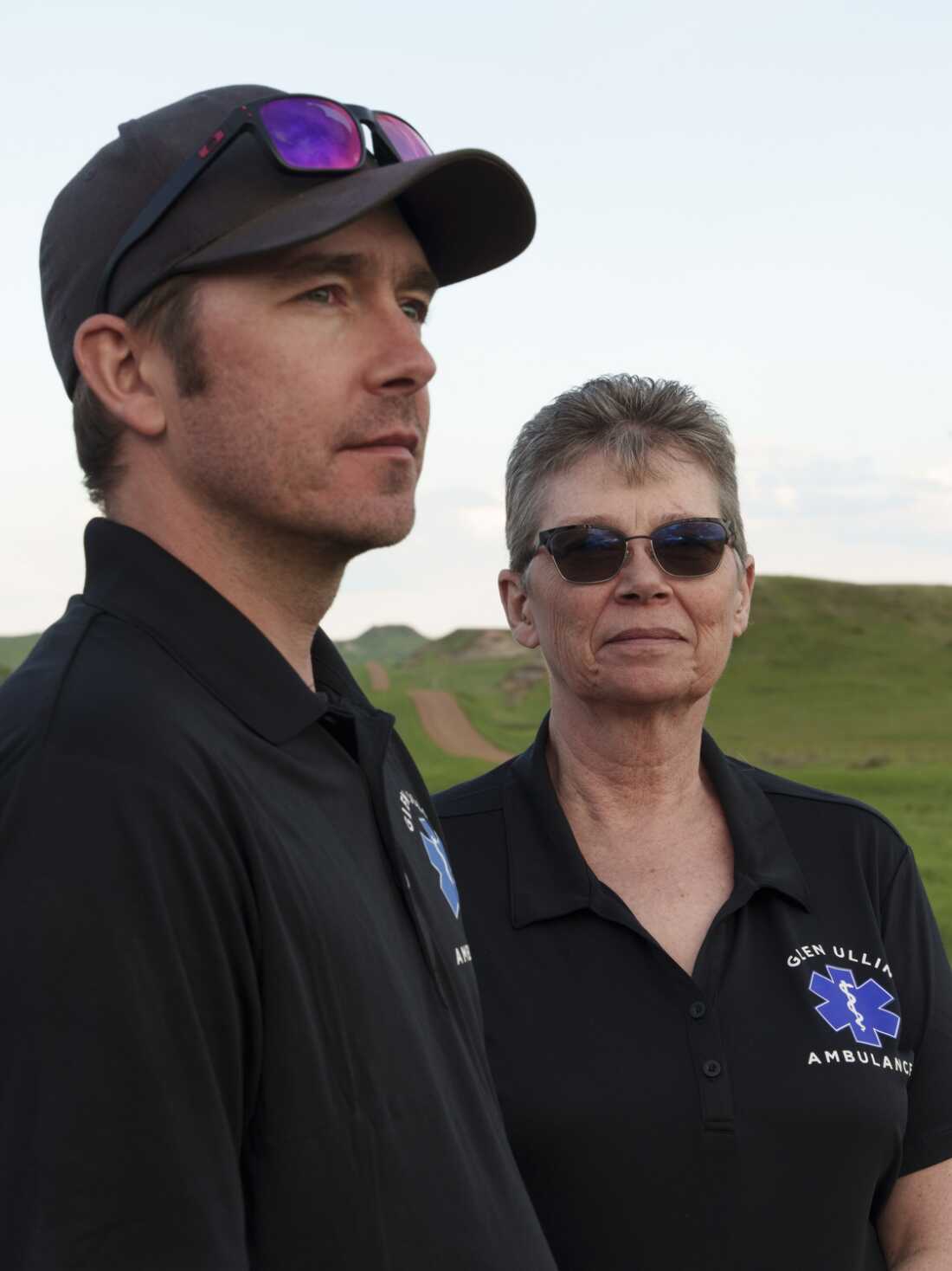 This photo shows Wade Kottre on the left and his mother, Lori Kottre, on the right. Both are Glen Ullin Ambulance Service EMTs, and both are wearing dark polo shirts that say 