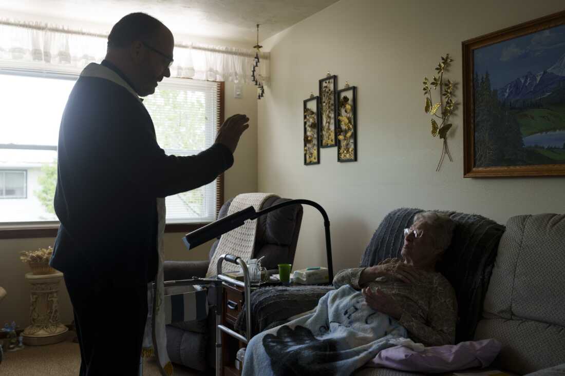 The Rev. Gary Benz offers Holy Communion to Viola Weinhardt, 94, at her home in Glen Ullin, N.D., on May 24. Benz offers Communion and the chance to connect with homebound, often socially isolated seniors who are dealing with health issues. 