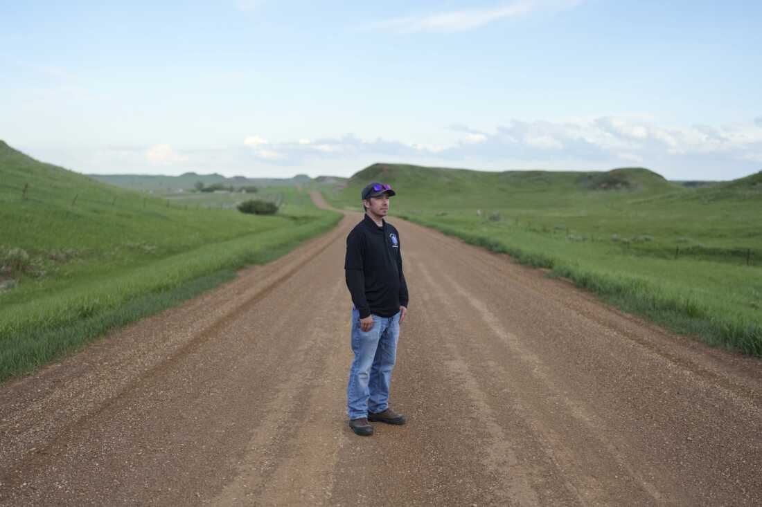 Wade Kottre, an EMT on the Glen Ullin Ambulance Service, stands for a portrait on a county road in Glen Ullin, N.D., on May 25. The ambulance service is staffed entirely by volunteers and provides an essential service for Glen Ullin and the surrounding area. While many of the volunteers are seniors themselves and have worked on EMT crews for decades, some younger volunteers have joined the team in recent years.