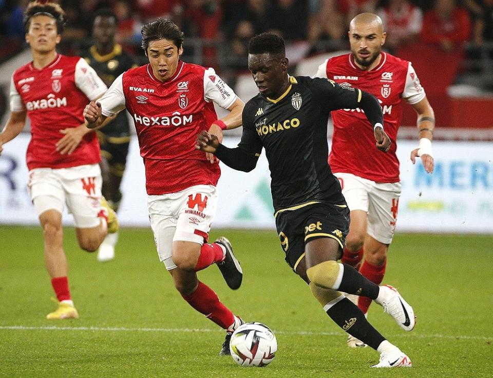 Reims' forward Junya Ito (L) fights for the ball with Monaco's forward #29 Folarin Balogun (R) during the French L1 football match between Stade de Reims and AS Monaco at Stade Auguste-Delaune in Reims, northern France on October 7, 2023. (Photo by FRANCOIS NASCIMBENI/AFP via Getty Images)