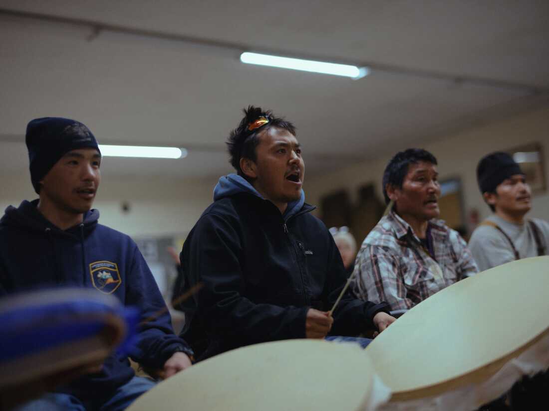 Gideon Green, (center), sings with a group of drummers at a Yup’ik dance practice in Hooper Bay that’s been supported by Qungasvik. For Green, who has lost several close friends to suicide, the group has proven integral to his healing.