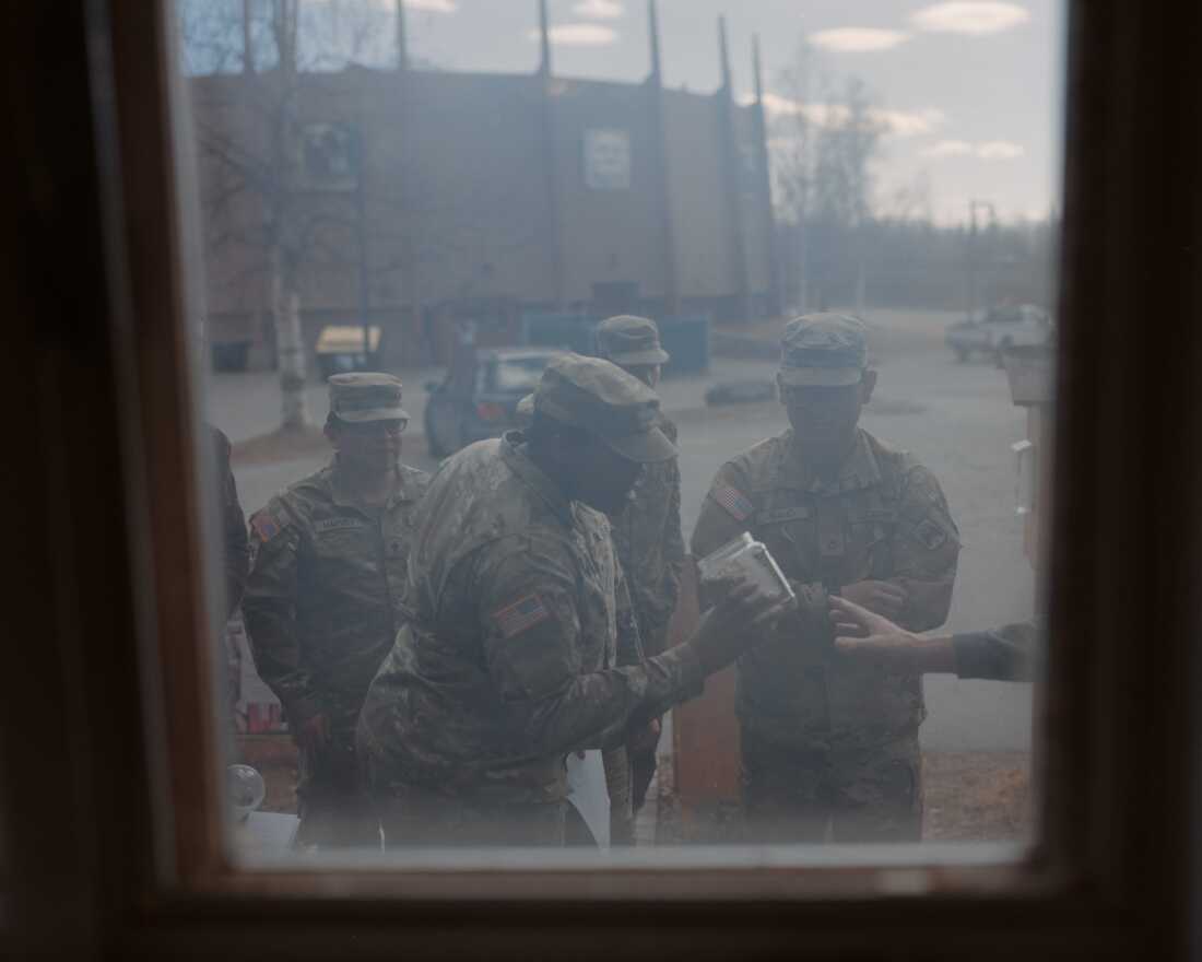 Soldiers from the 11th Airborne Division examine a jar of smoked salmon during a class at a local folk school in Fairbanks. These community outings are designed to help young soldiers build connections with their peers and their cultural surroundings in Alaska.