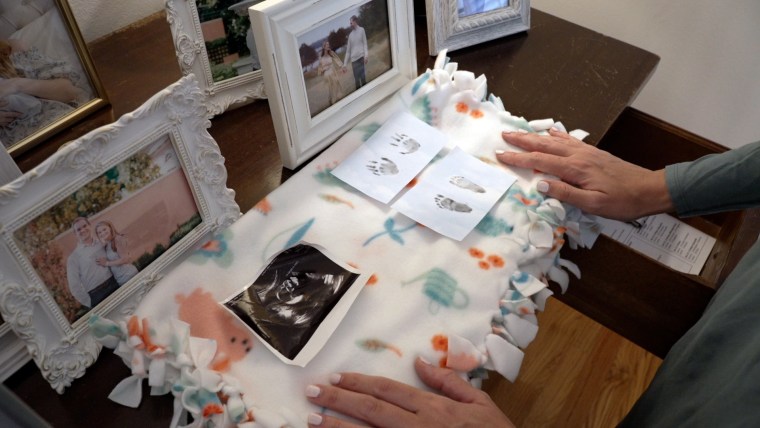 Emma looks at the footprints and sonogram of the baby she and her husband decided to abort after the diagnosis of a severe fetal anomaly.