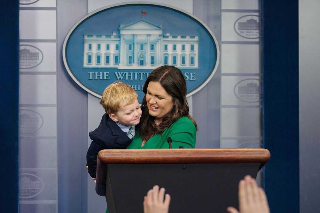 Sarah Huckabee Sanders plays with one of her sons in the briefing room on 