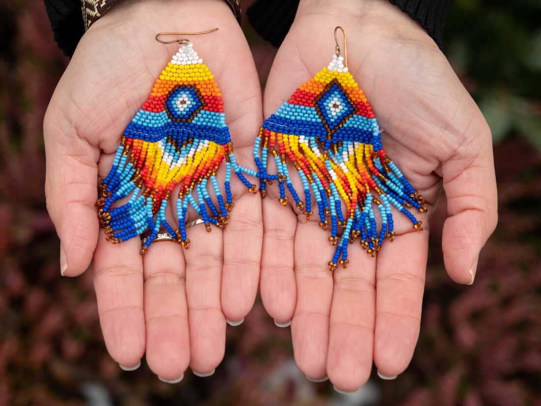 Kâlánguak is getting in touch with her Inuit roots through bead artistry. In her hands, she holds a pair of earrings that represent her two fathers — her adoptive father and her biological father.