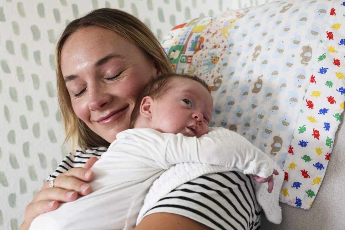 Mary Collins and her daughter, Rory. Mary has her eyes closed and is smiling serenely as she holds her daughter. 