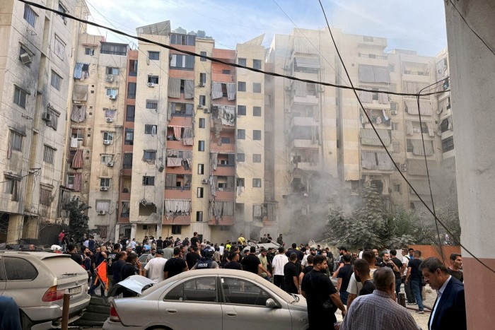 People inspect the site of an Israeli strike in the southern suburbs of Beirut, Lebanon