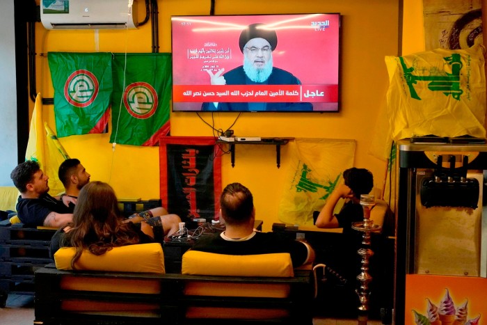 People watch the speech of Hizbollah leader Hassan Nasrallah as they sit in a cafe in the southern suburbs of Beirut