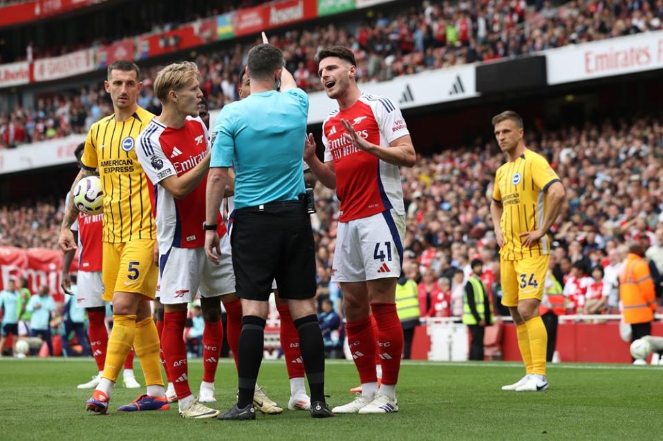 LONDON, ENGLAND: Declan Rice of Arsenal interacts with match referee Chris Kavanagh after being shown a second yellow card during the Premier League match between Arsenal FC and Brighton & Hove Albion FC at Emirates Stadium on August 31, 2024. (Photo by Ryan Pierse/Getty Images)