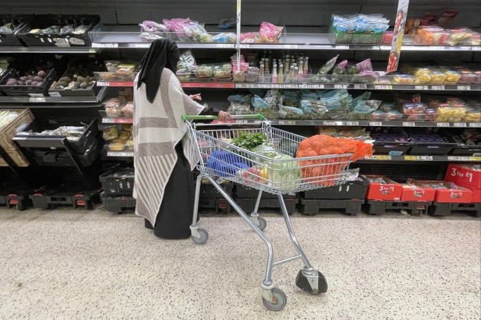 Shoppers buy groceries in an Asda supermarket in Manchester