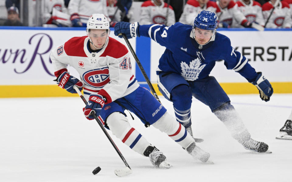 Sep 26, 2024; Toronto, Ontario, CAN; Montreal Canadiens forward Lane Hutson (48) controls the puck in front of Toronto Maple Leafs forward Bobby McMann (74) in the third period at Scotiabank Arena. Mandatory Credit: Dan Hamilton-Imagn Images