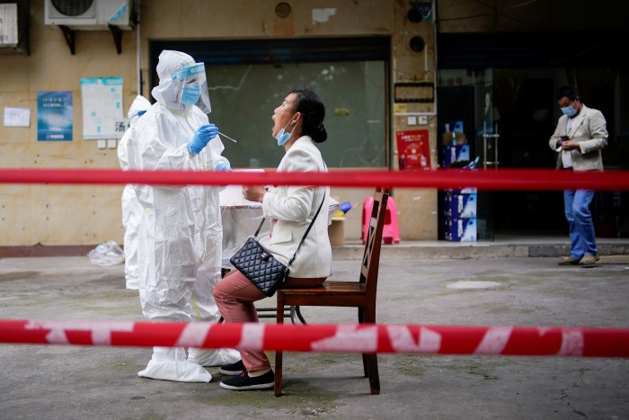 A medical worker conducts a test on residents in Wuhan in 2020