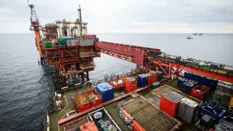 PA Media North Sea rig with industrial crates and ships in distance at sea on horizon